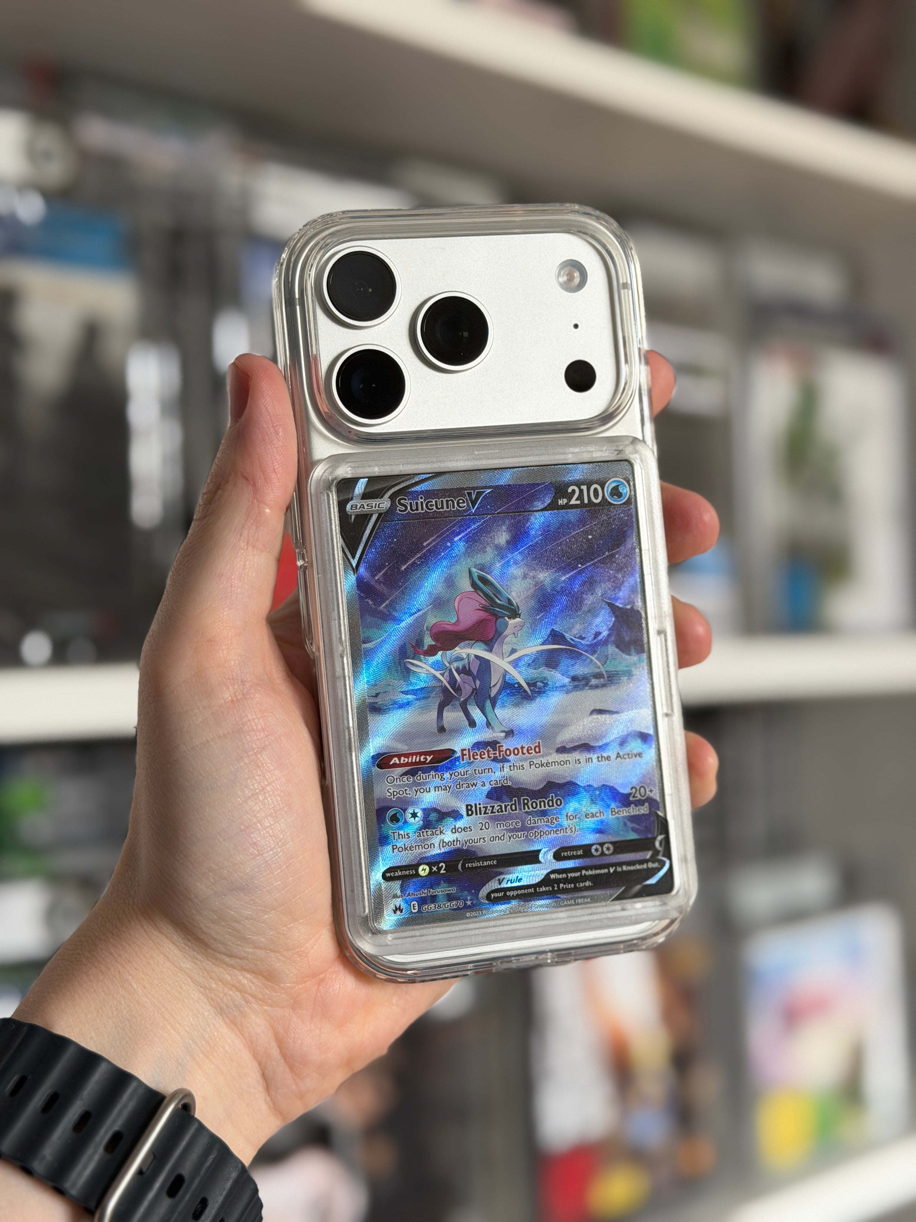 Transparent TCGCase phone case held in hand showing Suicune V Pokémon card, back angle