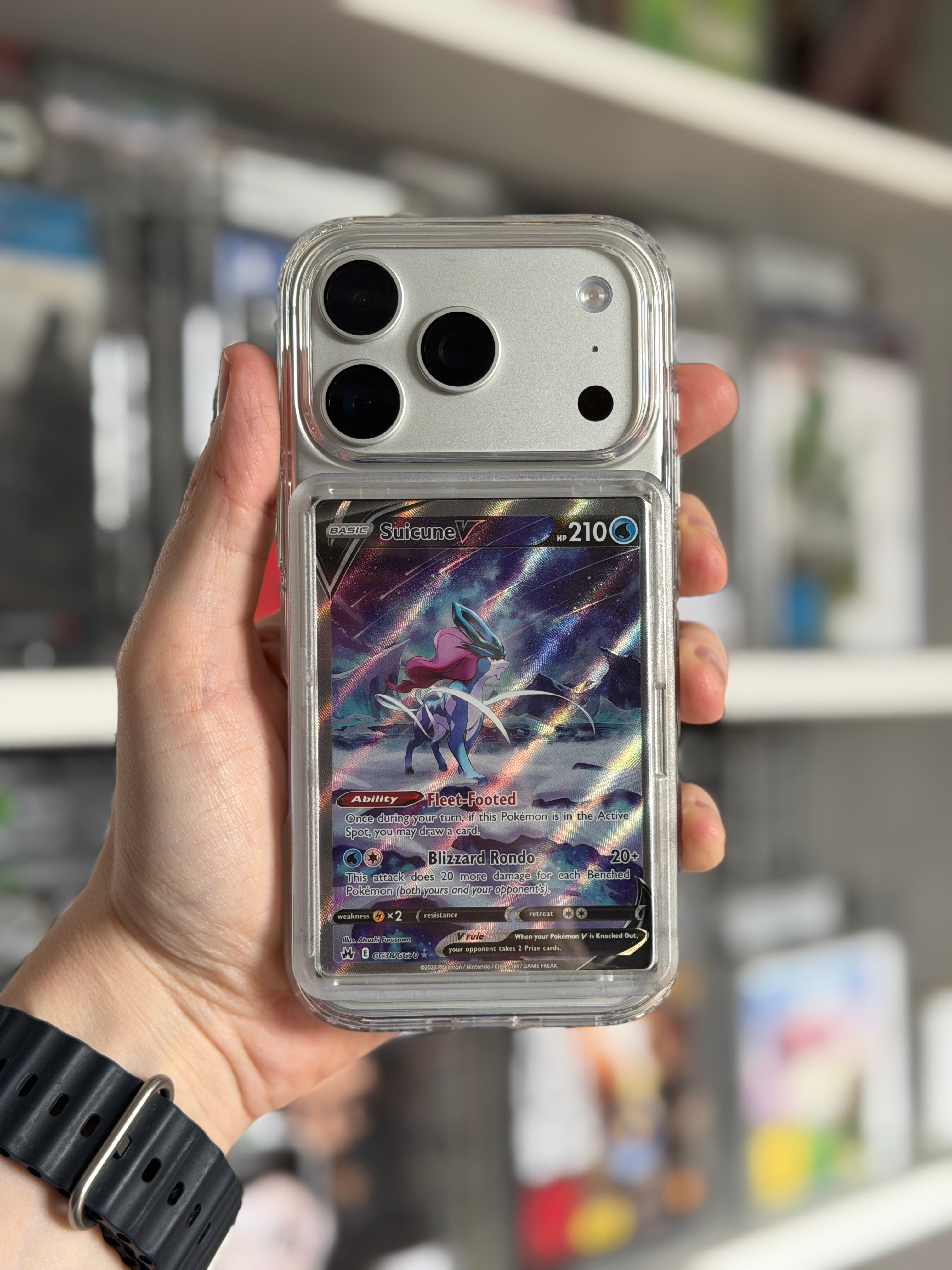 Transparent TCGCase phone case held in hand displaying Suicune V Pokémon card, front view
